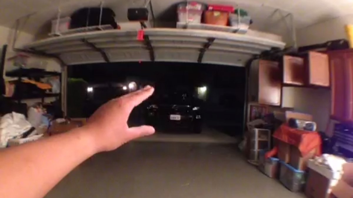 En person stänger garaget med sin hand.